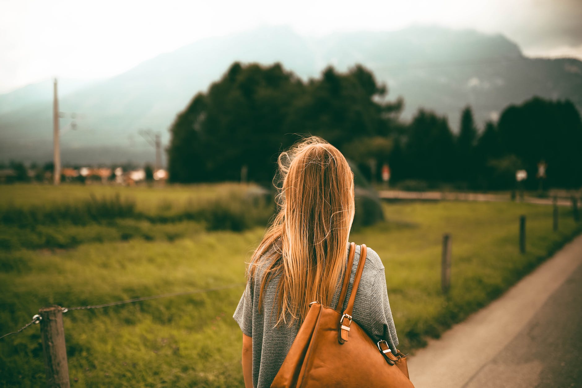 woman carrying brown leather bag