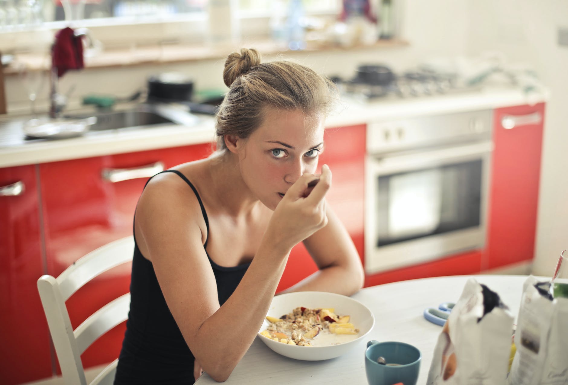 woman in black tank top eating cereals