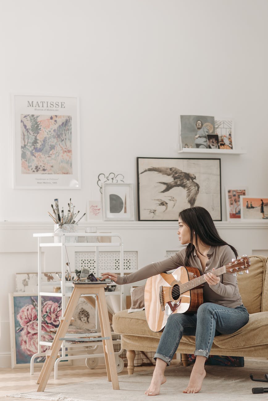 a woman in brown long sleeves playing acoustic guitar