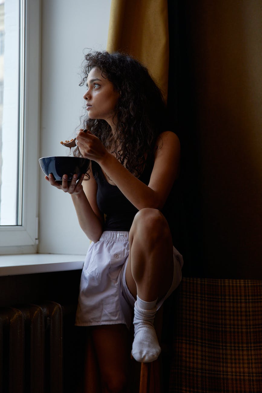 a woman eating alone while looking outside