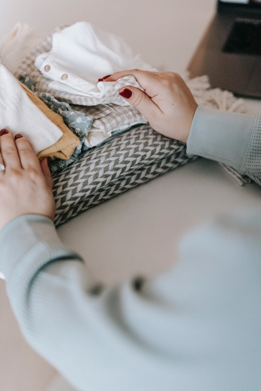 unrecognizable woman with folded clothes