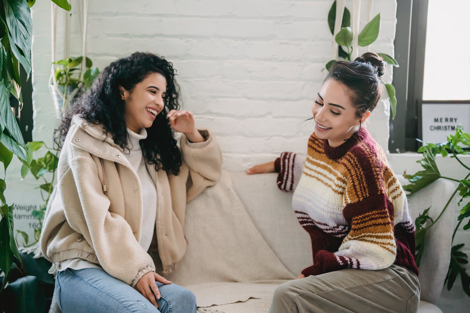 happy young women sitting on couch and talking
