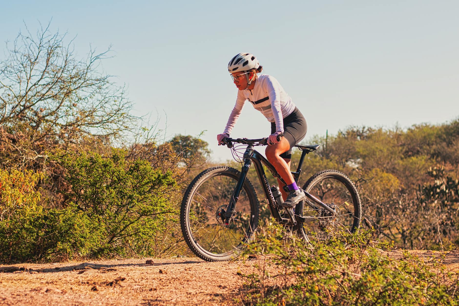 a woman riding a bike on a dirt road