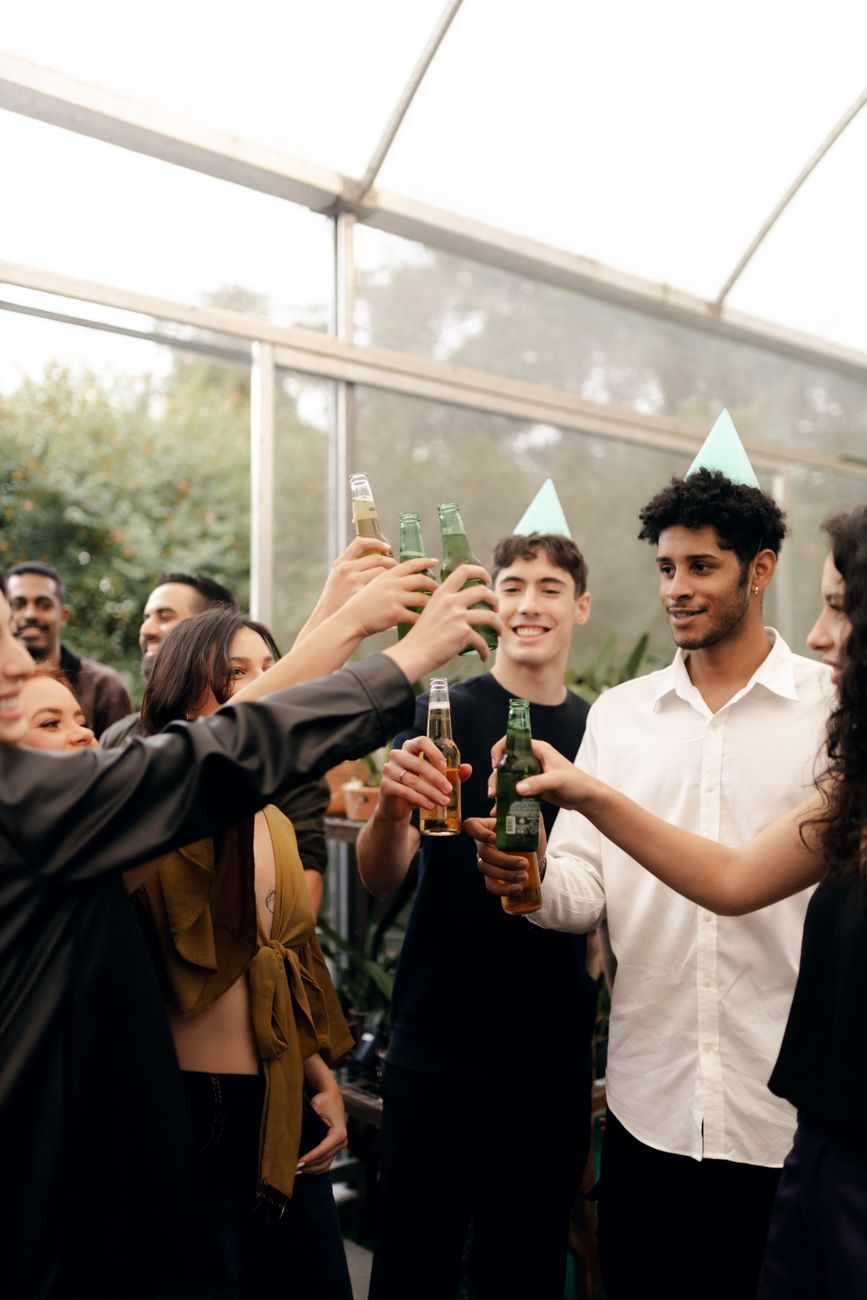 young adults celebrating with drinks and cheerful toast
