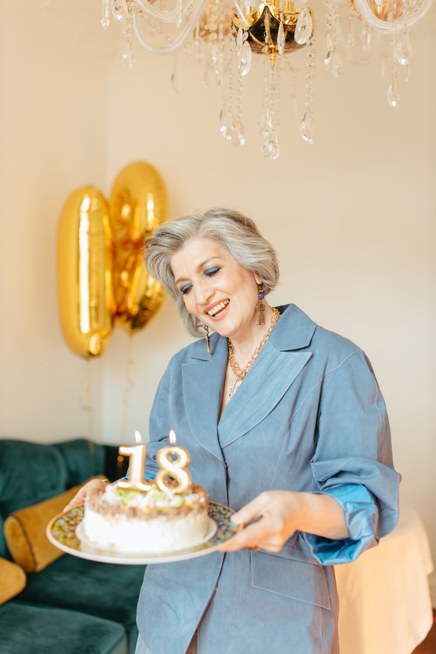 woman in blue long sleeves holding a cake