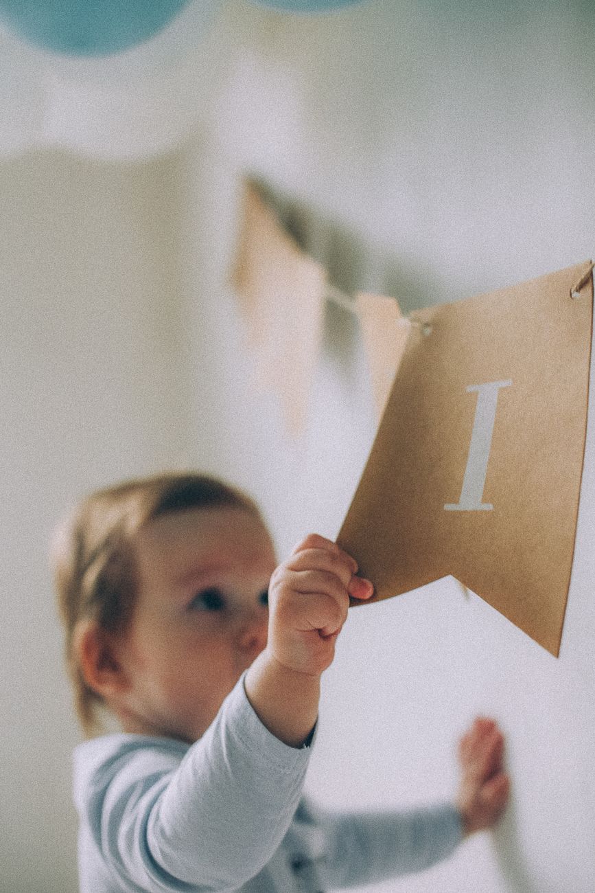 baby pulling a piece of a paper garland