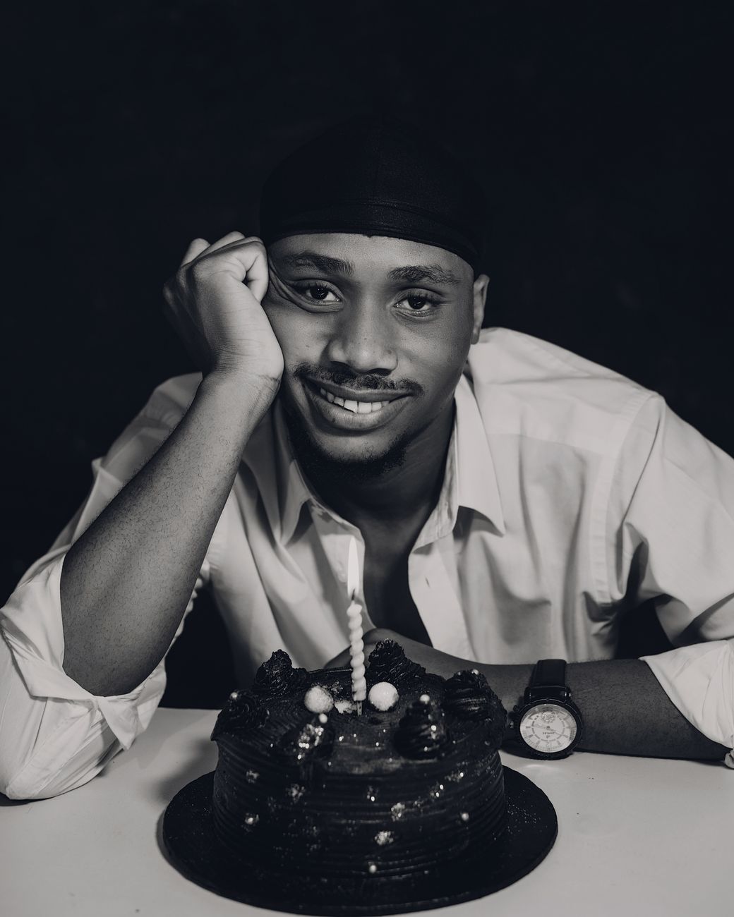 young man celebrating birthday with cake and candle